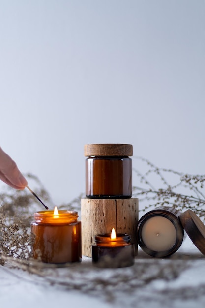 Un juego de velas de soja en un frasco de vidrio marrón con tapa de madera Vela aromática Aromaterapia