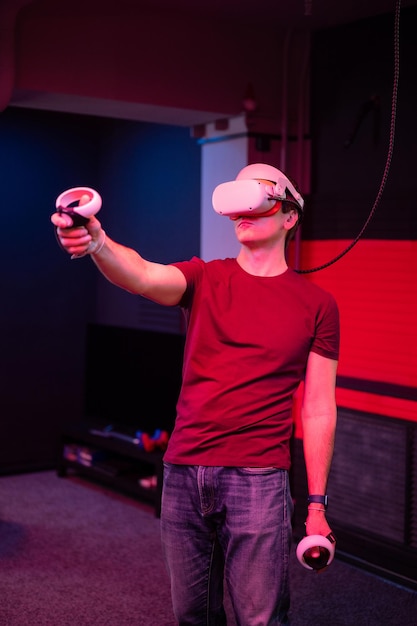 Juego vr y jugador de realidad virtual divertido jugando en un juego de disparos de video de simulación futurista en gafas 3d y pistola de joysticks en la sala de entretenimiento vr con tecnología de innovación y luz de neón