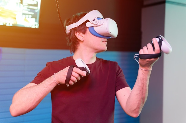 El juego vr y el jugador de realidad virtual se divierten jugando en la filmación de videos de simulación futurista o exploran el juego de estudio en gafas 3d y joysticks en la sala vr de entretenimiento con tecnología de innovación