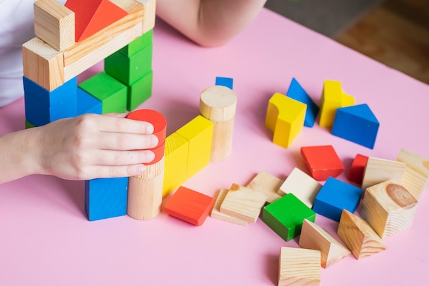 Los juegos de niños pequeños se ensamblan con el constructor de cubos de madera Concepto de educación para niños que aprenden Juguetes para niños