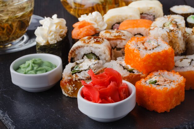 Juegos de rollos de sushi con pescado, arroz, queso crema y verduras.