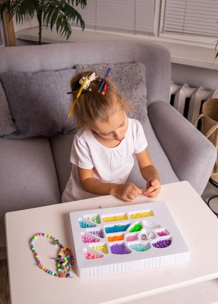 Juegos sensoriales con cuentas de colores con un niño en casa.