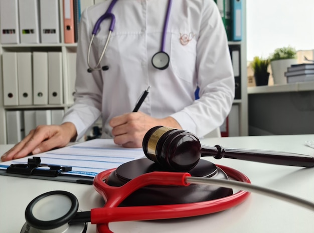 Foto el juez gavel esposó a un médico que se ocupaba de la papeleo de seguros en una clínica médica litigio en medicina