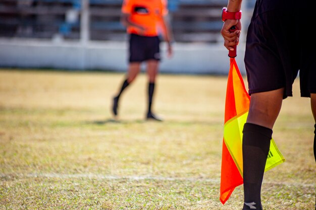 juez de línea en el campo de fútbol con su banderín árbitro de fútbol