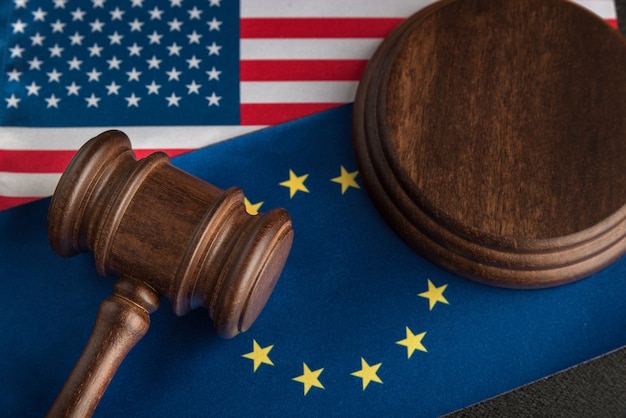 Juez con mazo sobre la bandera de Estados Unidos y la UE. Guerra comercial. Enfrentamiento legal Estados Unidos de América y Unión Europea.