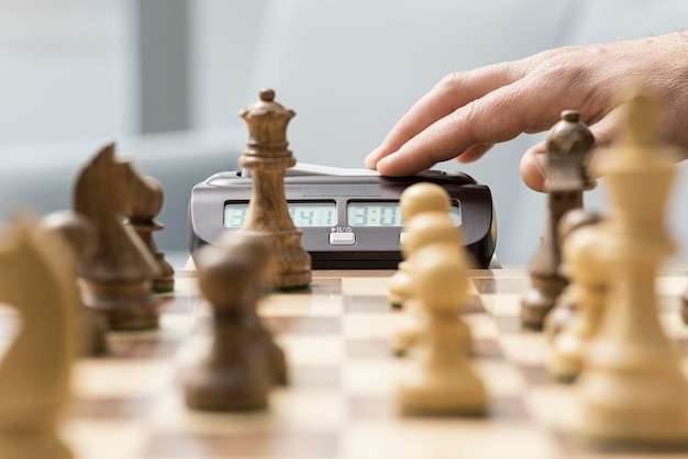 Jugador de ajedrez golpeando el concepto de competición y torneo de ajedrez del reloj de ajedrez