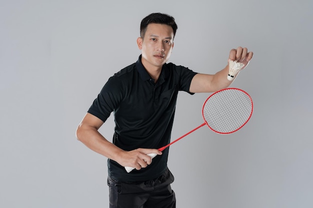 Jugador de bádminton con ropa deportiva de pie sosteniendo una raqueta
