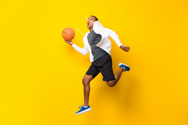 Jugador de baloncesto afroamericano hombre sobre amarillo aislado