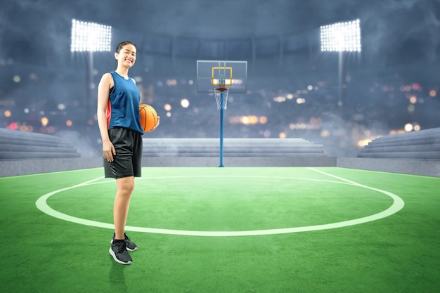 Jugador de baloncesto asiático mujer sosteniendo la pelota