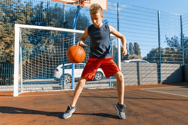 Jugador de baloncesto callejero muchacho adolescente caucásico con pelota