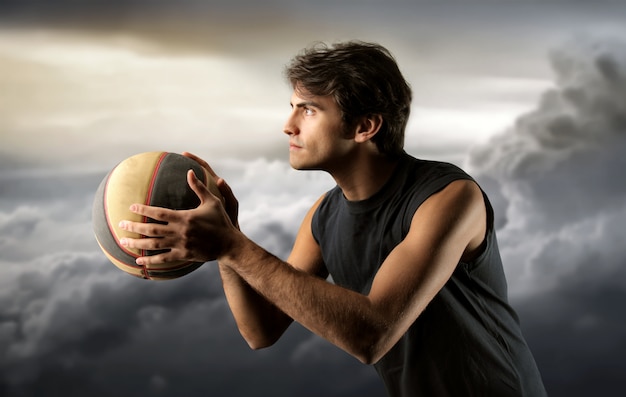 Foto jugador de baloncesto y un cielo nublado