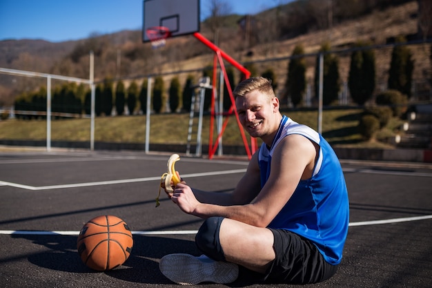 Jugador de baloncesto comiendo banana