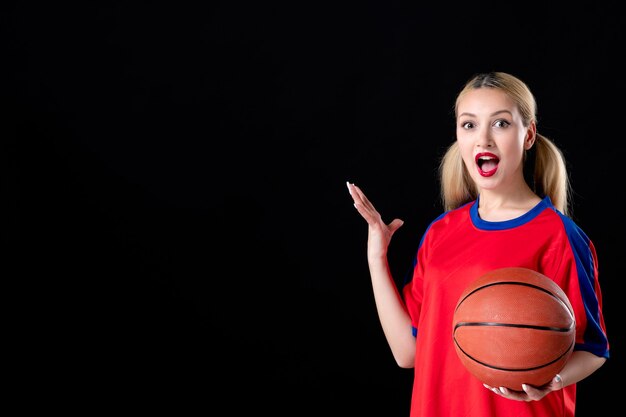 Jugador de baloncesto femenino con balón sobre fondo oscuro aislado acciones de juego de atleta