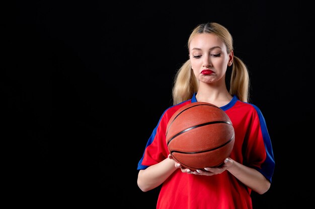 Jugador de baloncesto femenino en ropa deportiva con pelota sobre fondo negro juegos atleta jugar