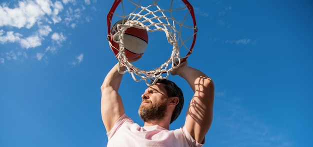 El jugador de baloncesto lanza la pelota al aro fuera del pasatiempo deportivo