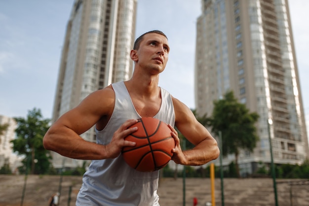 Jugador de baloncesto con el objetivo de lanzar en la cancha al aire libre.