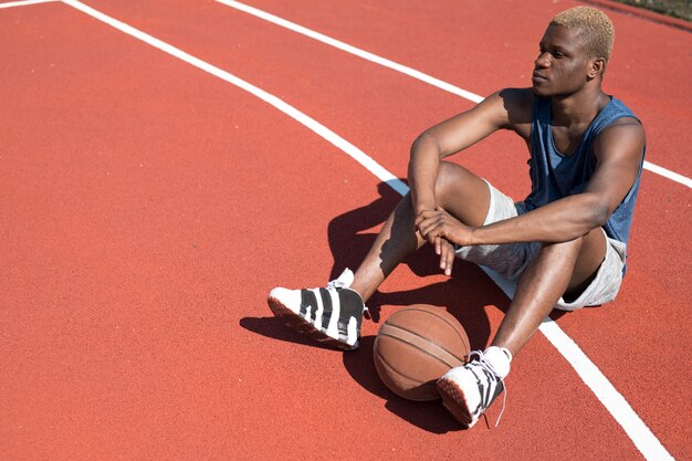 Jugador de baloncesto sentado en la cancha