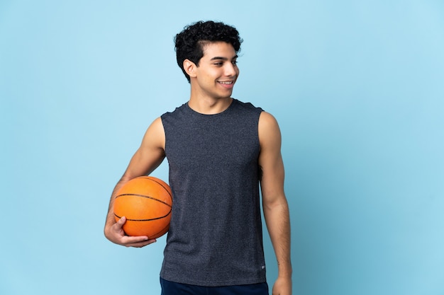 Jugador de baloncesto venezolano hombre sobre antecedentes aislados mirando hacia el lado y sonriendo