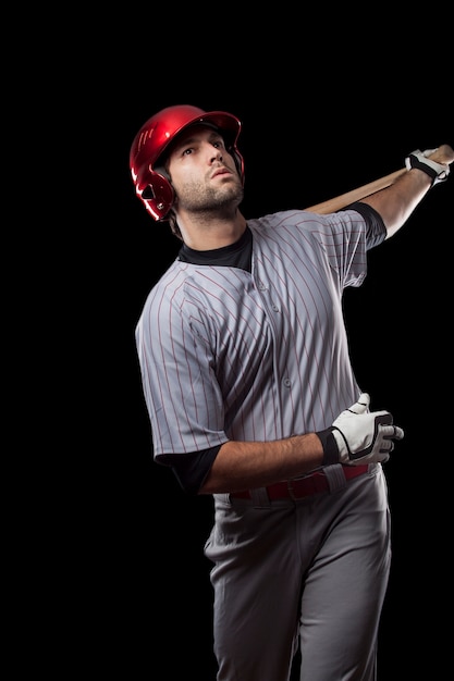 Jugador de béisbol joven con un casco rojo