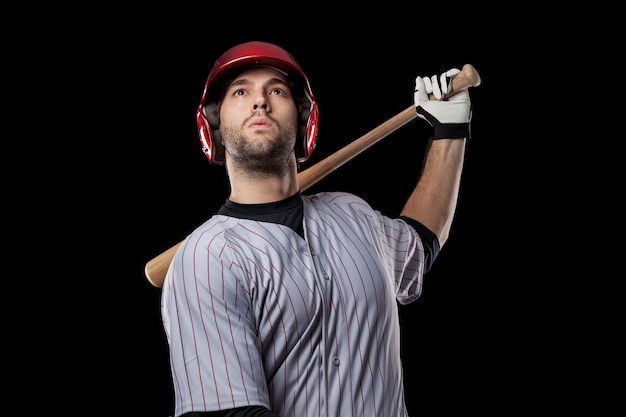 Jugador de béisbol joven con un casco rojo