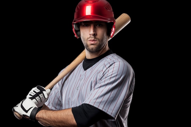 Jugador de béisbol joven con un casco rojo