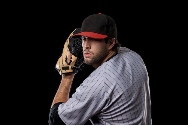 Jugador de béisbol lanzando una pelota. Foto de estudio.