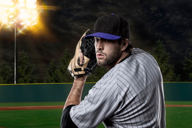 Foto jugador de béisbol en un uniforme azul en el estadio de béisbol.