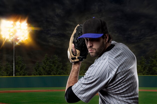 Jugador de béisbol en un uniforme azul en el estadio de béisbol.