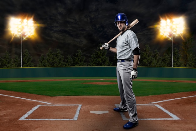 Jugador de béisbol en un uniforme azul en el estadio de béisbol.