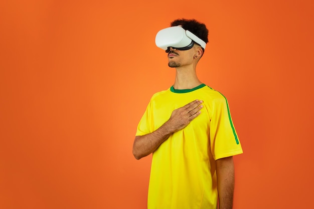 Jugador brasileño Black Man celebrando con gafas virtuales VR aisladas sobre fondo naranja