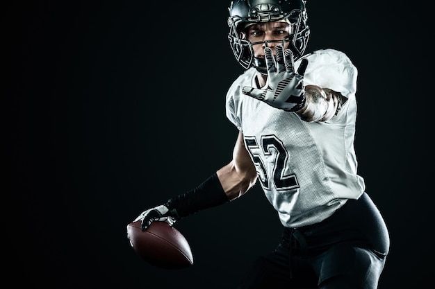 Jugador de deportista de fútbol americano en casco aislado sobre fondo negro Fondo de pantalla de deporte y motivación