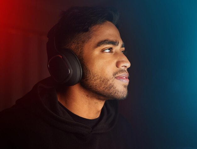 El jugador de eSports y el hombre en línea por la noche en la batalla de la competencia o el desafío de los videojuegos de RPG virtuales El nerd de los juegos y la habitación oscura para la transmisión en vivo del concurso cibernético en casa con luces de neón o maqueta tecnológica