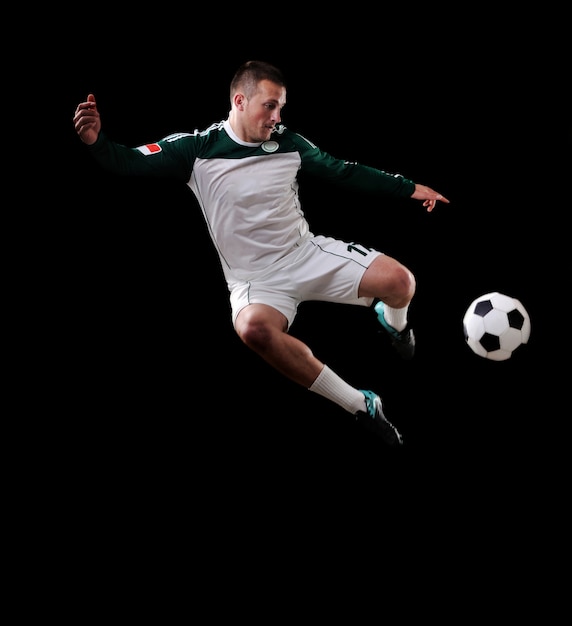 Jugador de fútbol en el aire sobre fondo negro