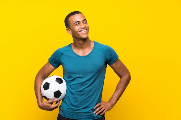 Jugador de fútbol americano africano hombre mirando hacia arriba mientras sonríe