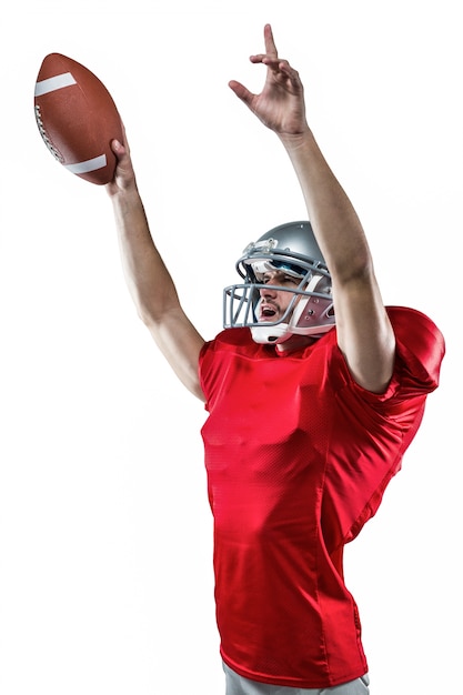 Jugador de fútbol americano sosteniendo la bola mientras apunta hacia arriba
