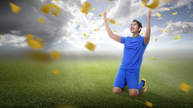 El jugador de fútbol asiático con una camiseta azul celebra la victoria