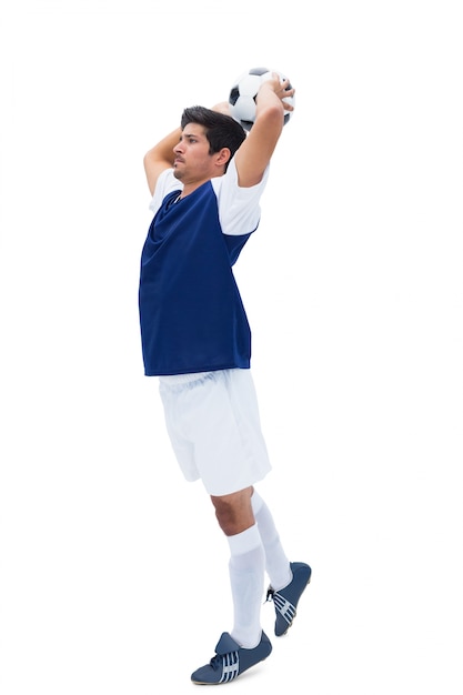 Foto jugador de fútbol en blanco lanzando la pelota