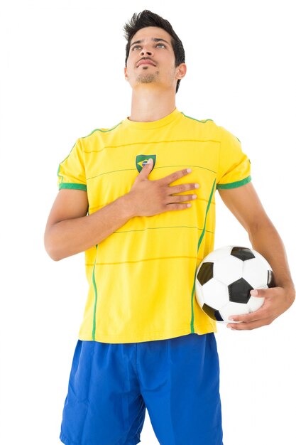 Foto jugador de fútbol brasileño escuchando el himno