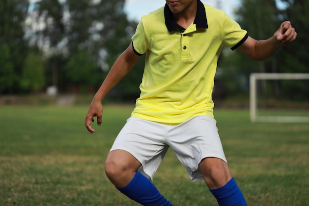 Jugador de fútbol con una camiseta amarilla y leggings azules en el campo de fútbol