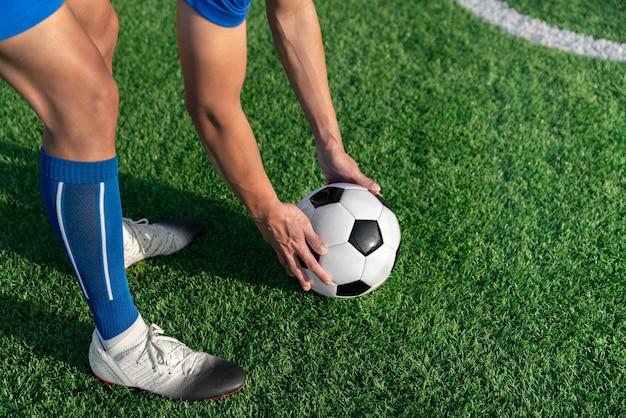 El jugador de fútbol colocó la pelota de fútbol en el césped en el punto de tiro libre antes de disparar o patear para ganar un puntaje en el partido de fútbol de la liga internacional