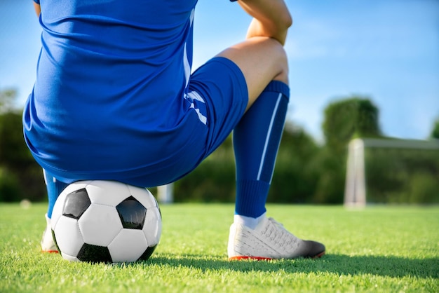 El jugador de fútbol colocó la pelota de fútbol en el césped en el punto de tiro libre antes de disparar o patear para ganar un puntaje en el partido de fútbol de la liga internacional