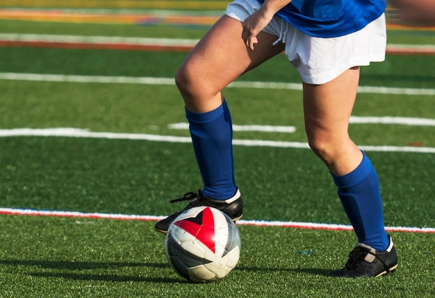 Foto un jugador de fútbol controlando la pelota mientras corre por un campo de césped verde durante un juego