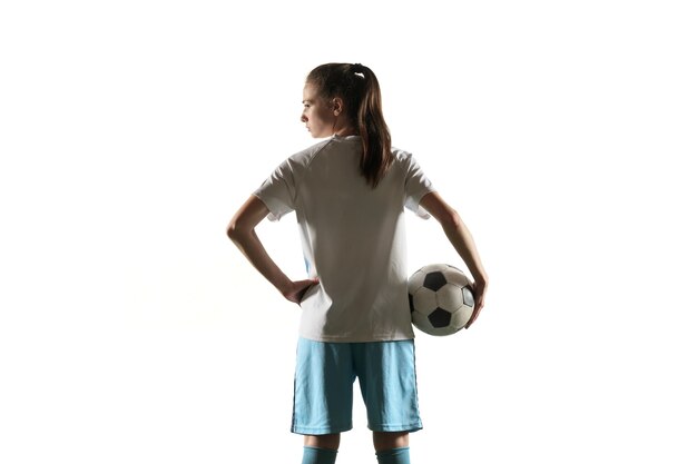 Jugador de fútbol femenino de pie con el balón aislado sobre fondo blanco.