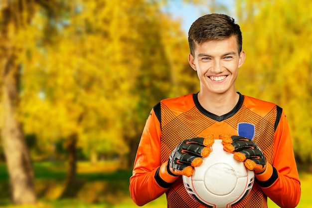 jugador de fútbol de fútbol joven atleta. parque al aire libre, día soleado de otoño