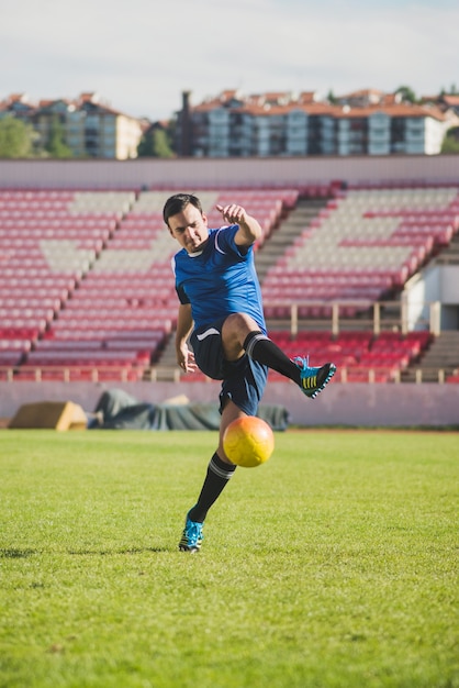 Foto jugador de fútbol golpeando pelota