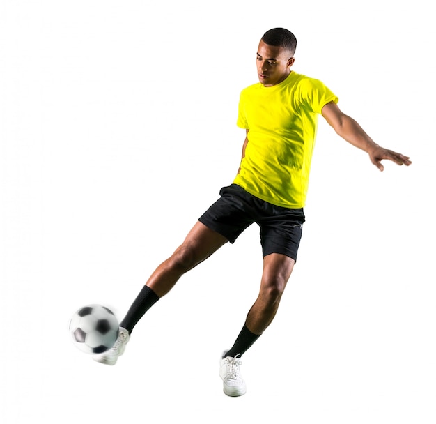 Jugador de fútbol hombre con piel oscura jugando pateando la pelota