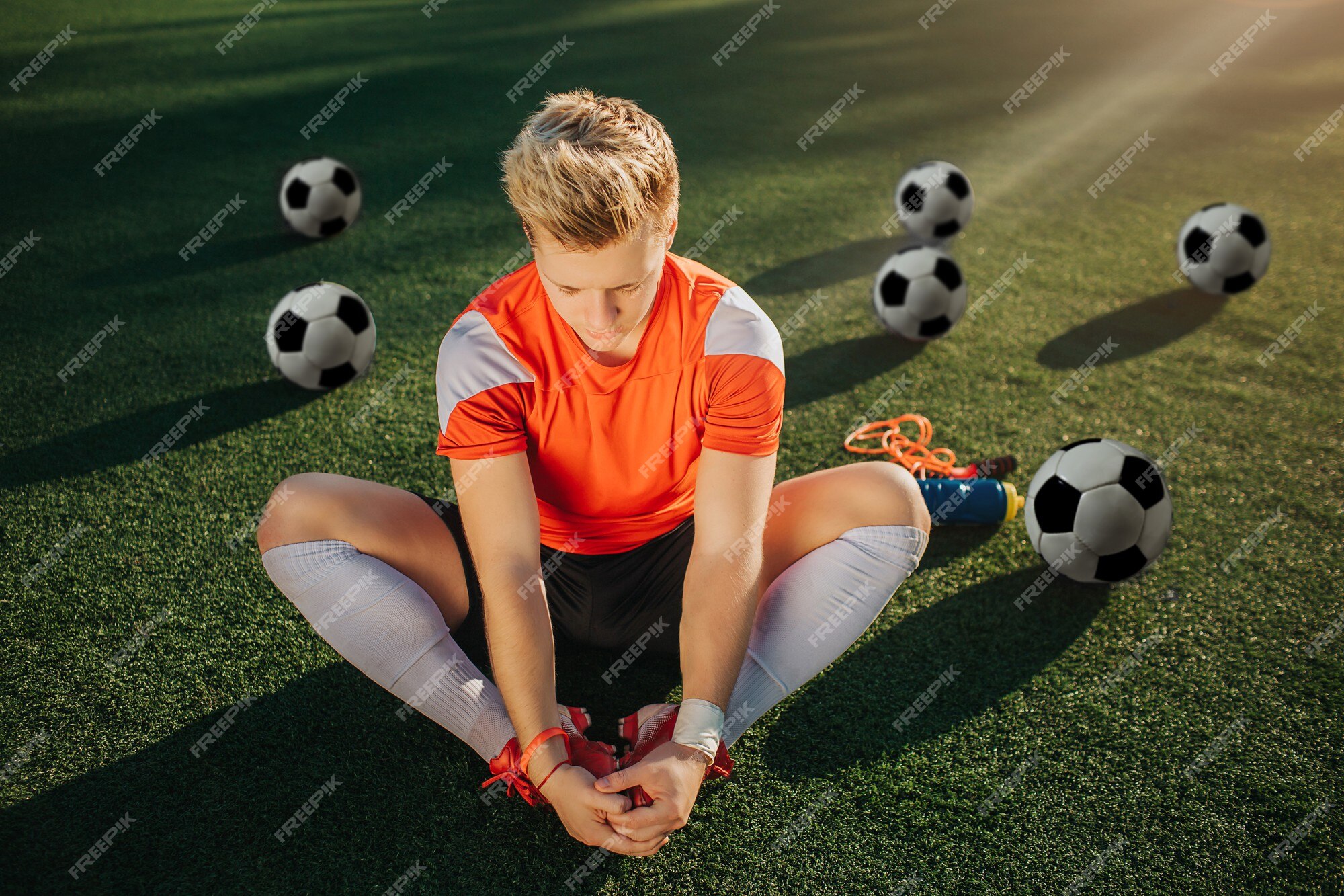 de fútbol joven sentado el césped y Foto Premium