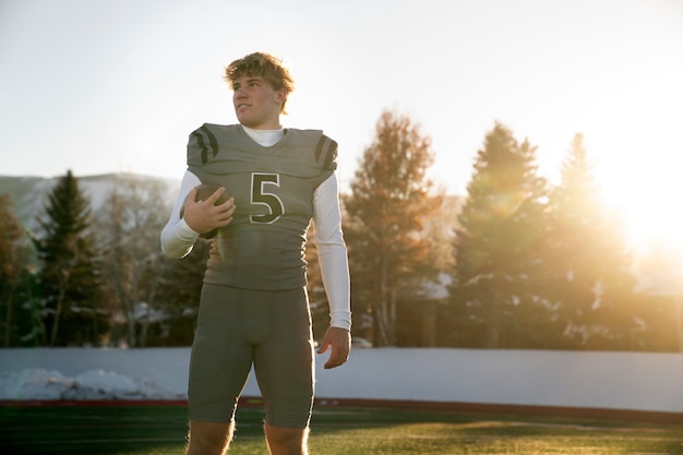 Foto jugador de fútbol masculino americano en uniforme en el campo