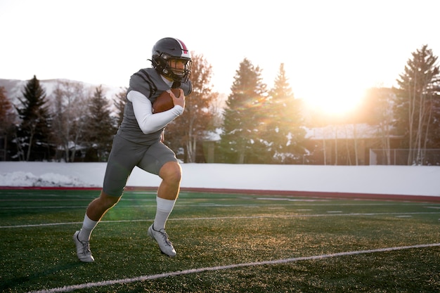 Foto jugador de fútbol masculino americano en uniforme en el campo