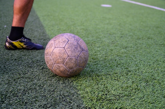 Jugador de fútbol masculino jugando al fútbol en el césped verde